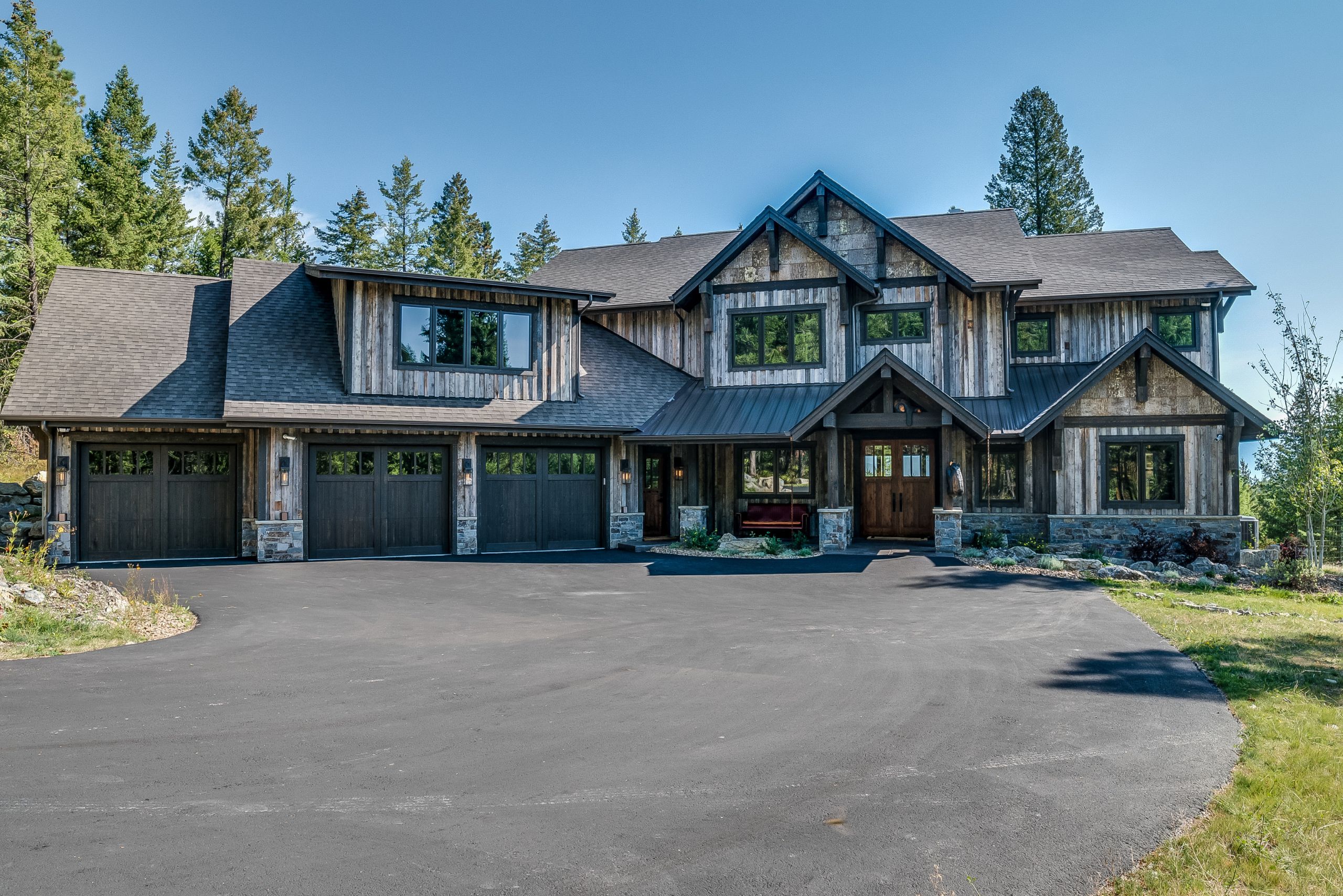 two story home with wide, curved asphalt driveway in front