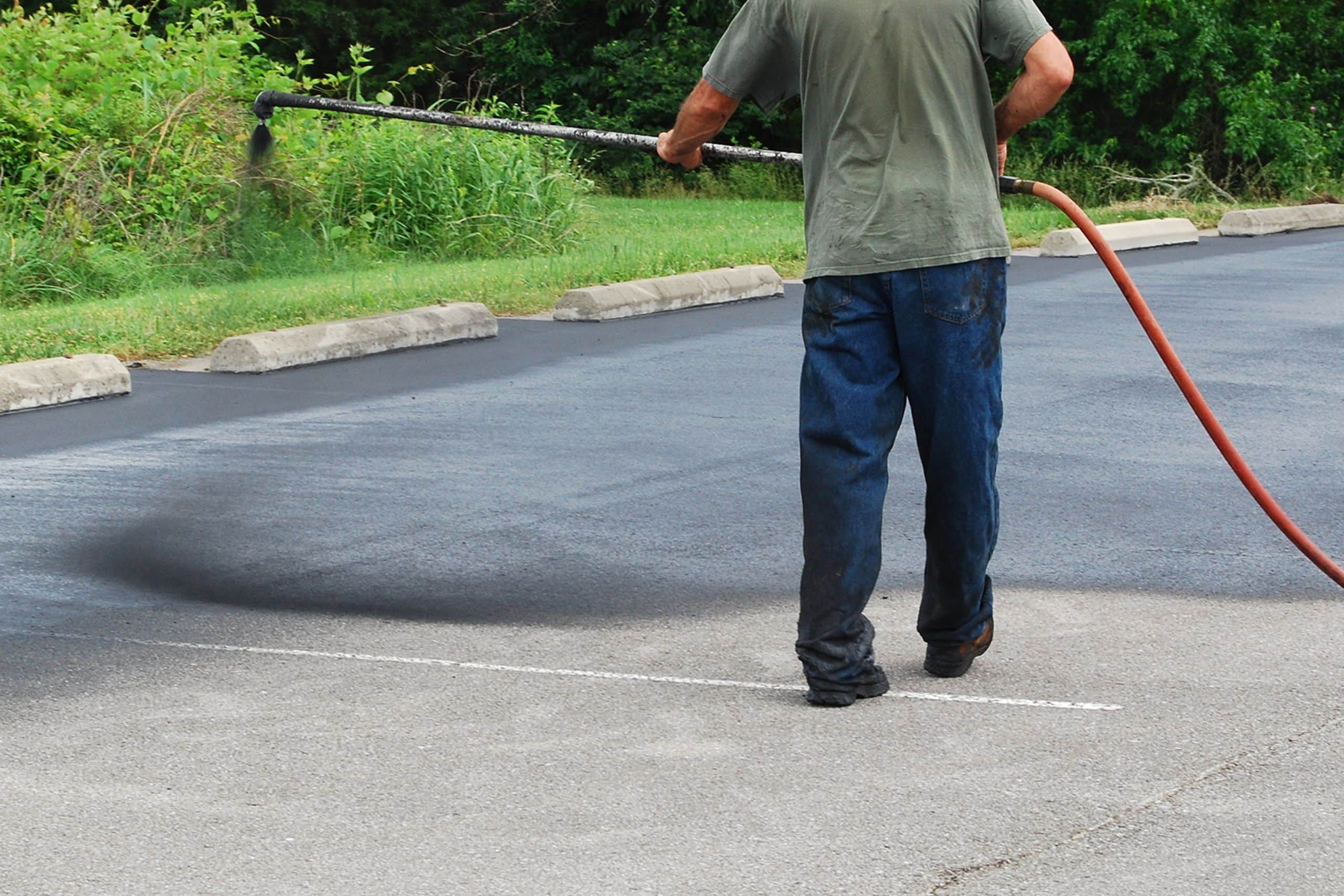 asphalt contractor using sealcoating to maintain asphalt