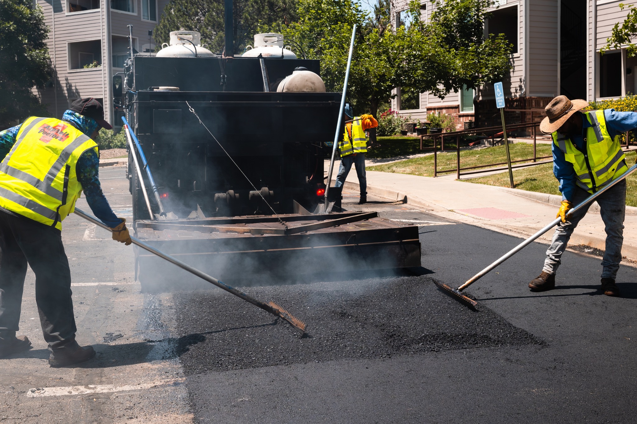 workers paving asphalt in high visibility vests