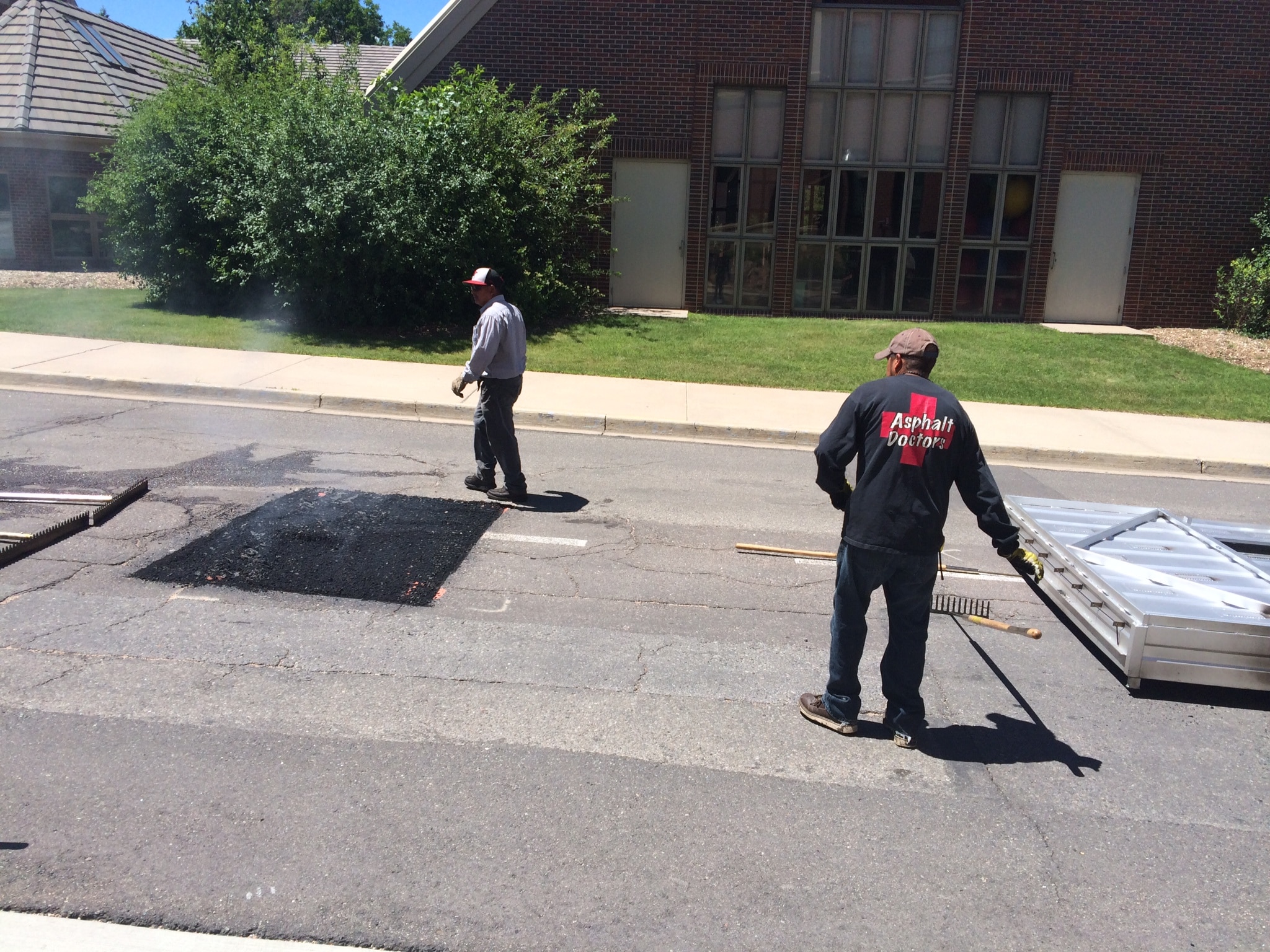 two men working on infrared asphalt patching