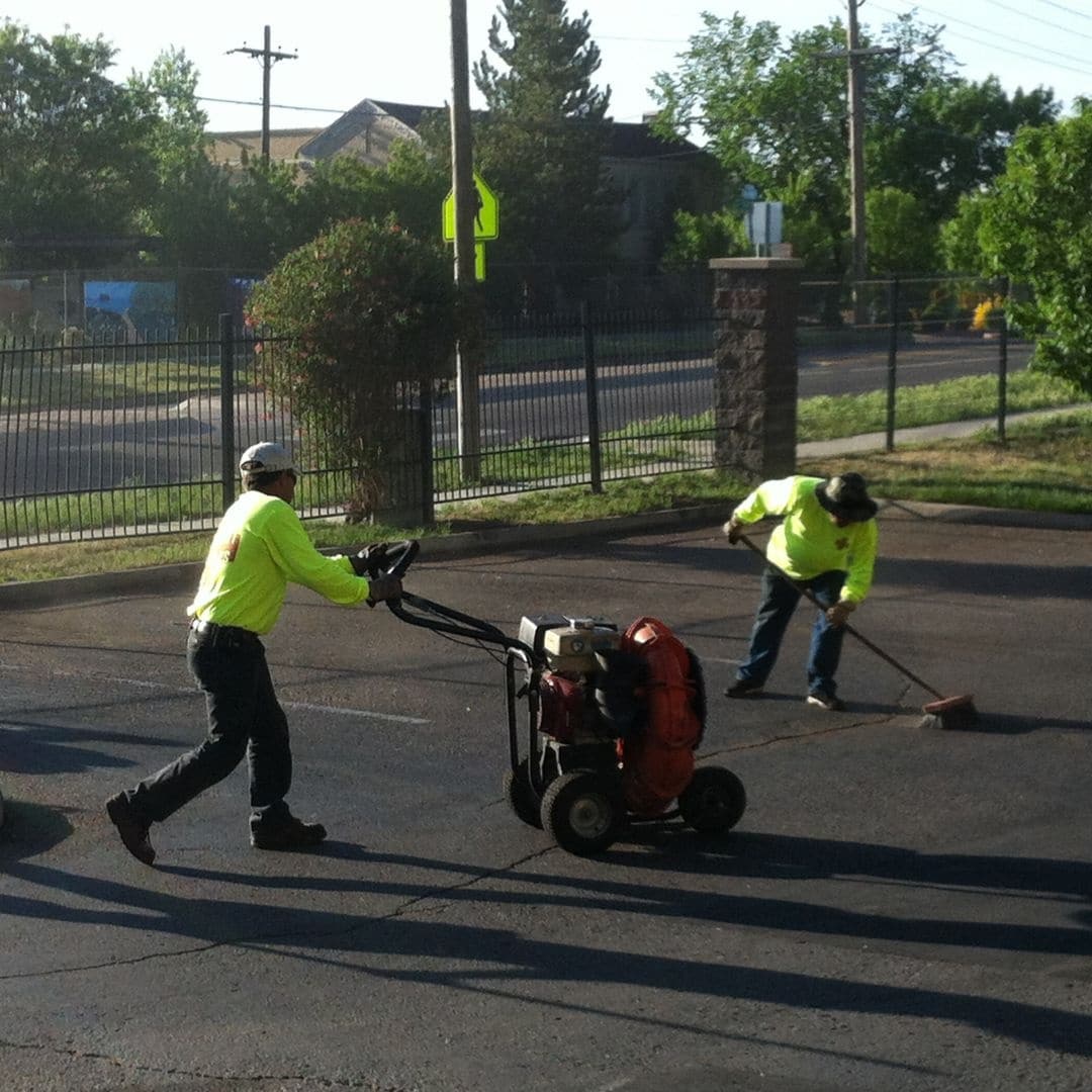 workers using asphalt paving tools working on a parking lot