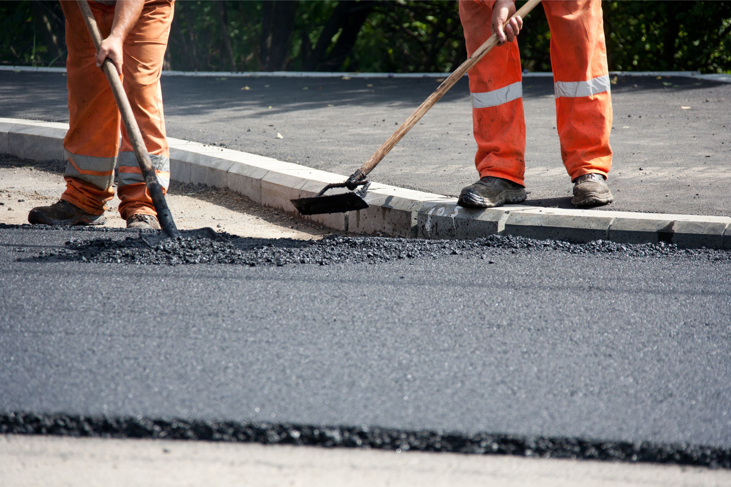 two workers performing asphalt repairs